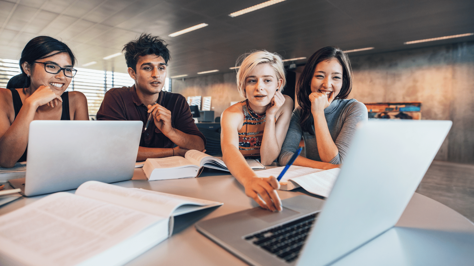 Young Indian students studying with computers